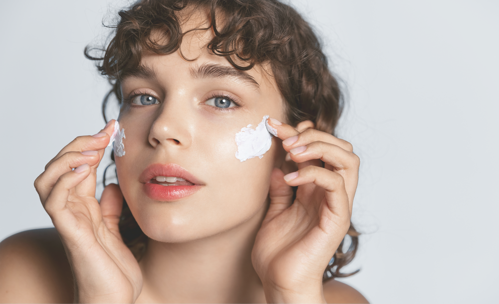 A lady applying facial cream on face